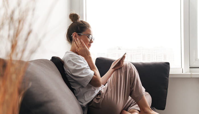 Dame som sitter å ser på telefonen