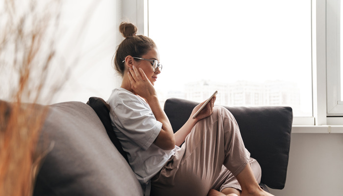 Dame som sitter å ser på telefonen