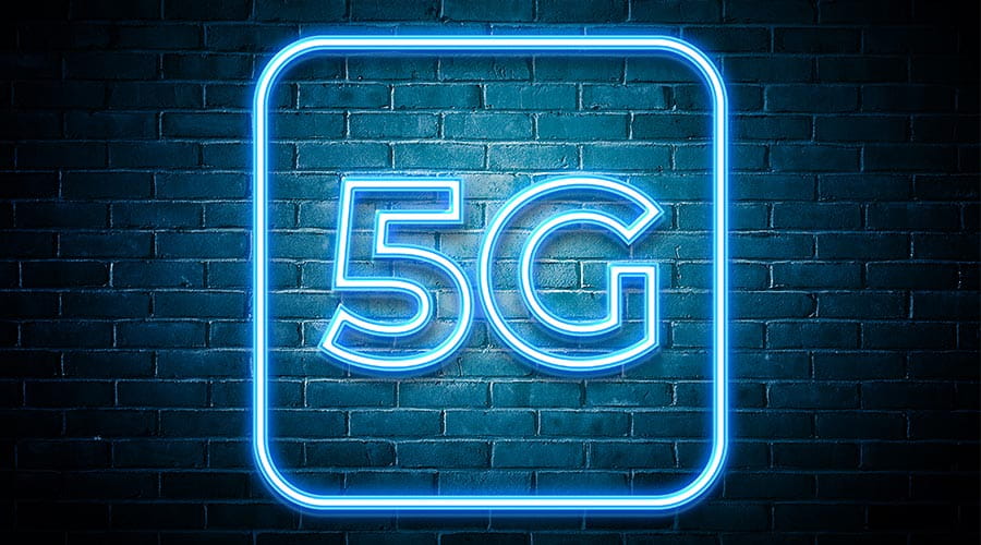 Neon 5G-skilt hengende på en murvegg