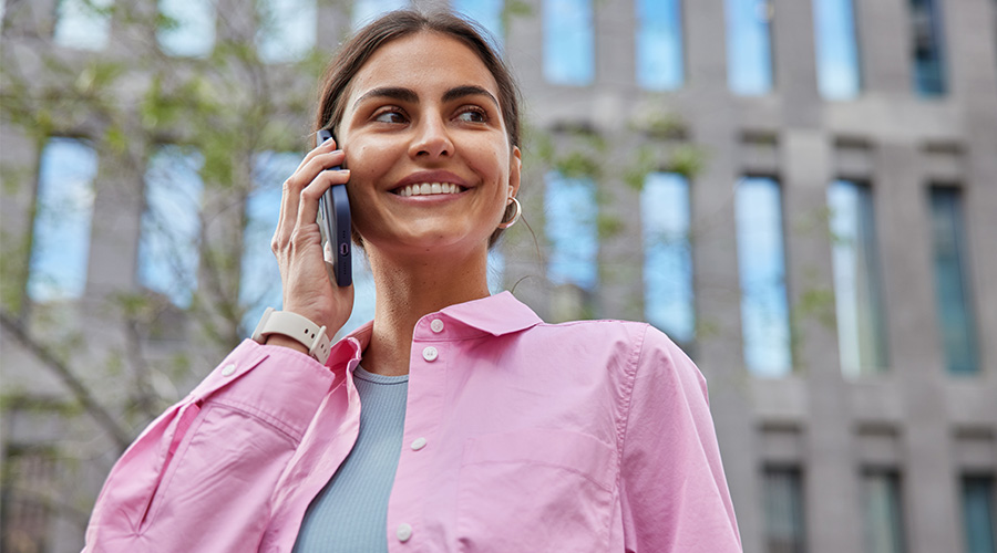 Kvinne som snakker i telefonen mens hun smiler