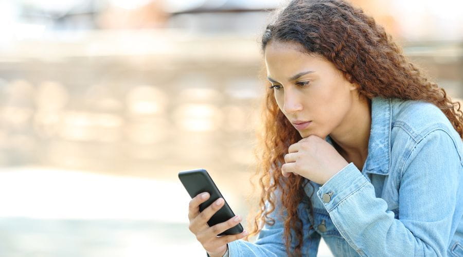 Kvinne som ser på telefonen fokusert