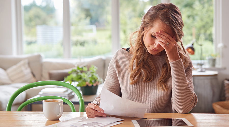 Dame som ser oppgitt ut mens hun ser på en regning