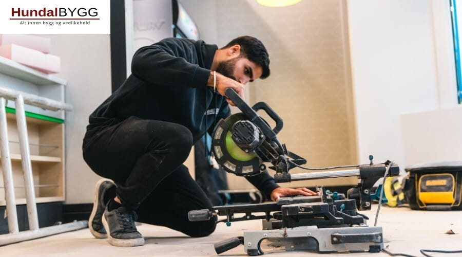 Bilde av en håndverker fra Hundalbygg som står å sager ett trestykke