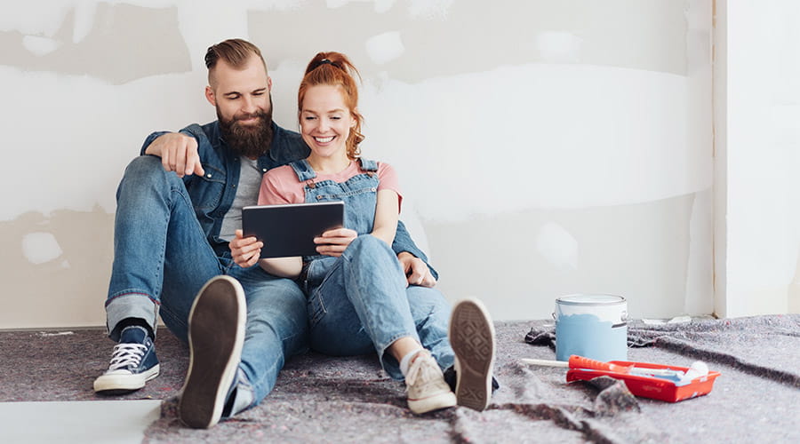 Ett kjærestepar som sitter lent til en umalt vegg