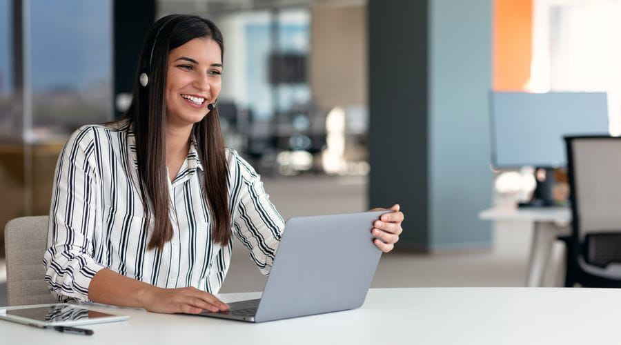 Kvinne som snakker med et headset på et kundesenter