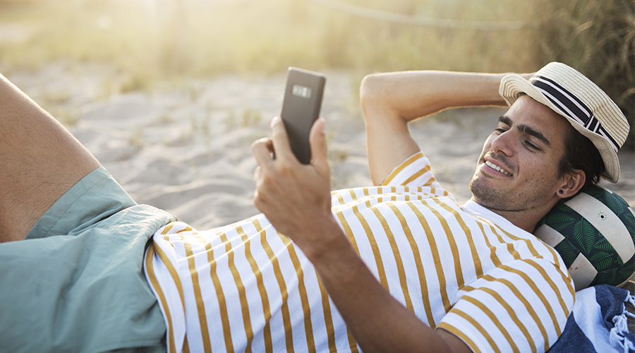 Mann som ligger på stranden med en stråhatt