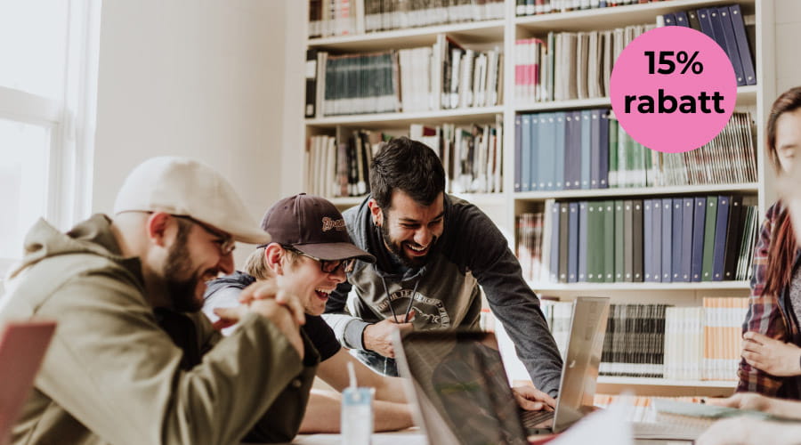 Kollegaer ser på en pc-skjerm sammen med et merke med 15% rabatt