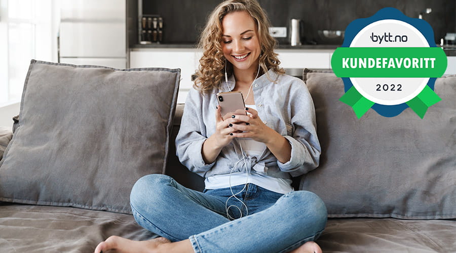 Dame som sitter på telefonen med kundefavoritt på bytt.no emblem