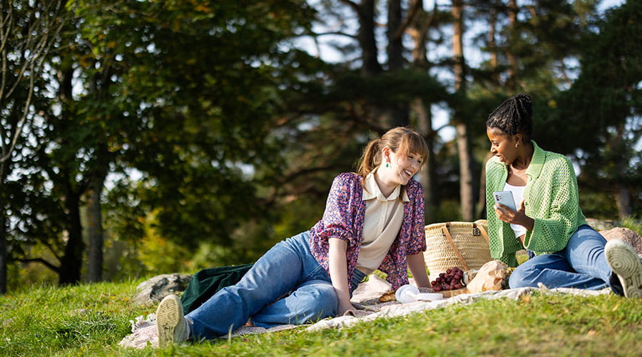 Jenter som har lunsj i parken