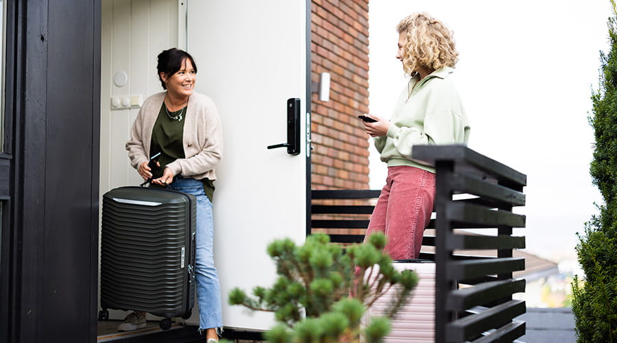 Mor og datter på vei ut av døren med kofferter