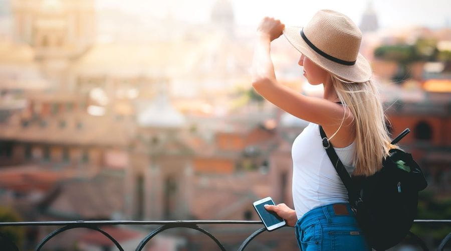 Bilde av en jente med solhatt som ser utover roma