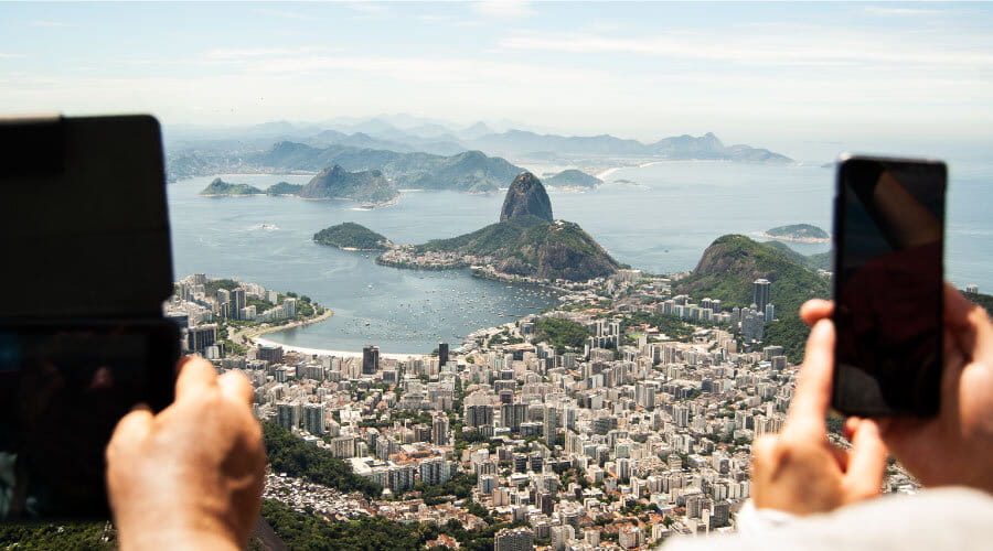 To personer som tar bilde fra kristusstatuen over Rio de Janeiro