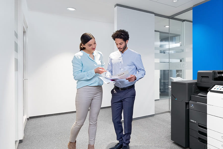 Bilde av to kollegaer som går gjennom en kontor-gang